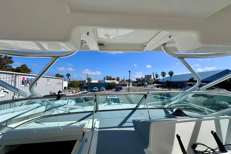 Slide: The Image of 2001 Wellcraft 290 Coastal boat interior view with clear sky and marina background. - 8