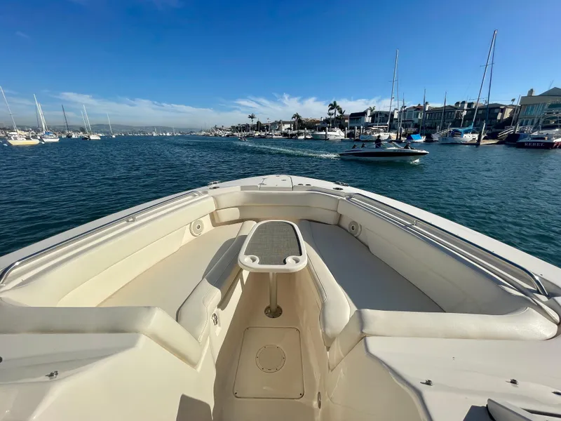 Slide: The Image of 2017 Grady-White 307 Freedom boat on calm waters, surrounded by sailboats and coastal scenery. - 15