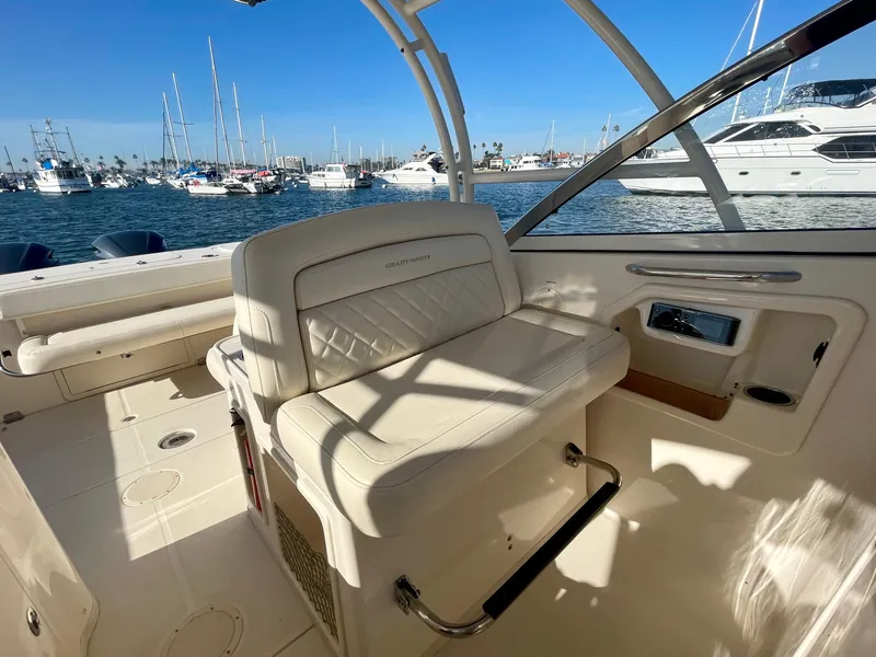 Slide: The Image of 2017 Grady-White 307 Freedom boat interior with white seating, docked in marina. - 18