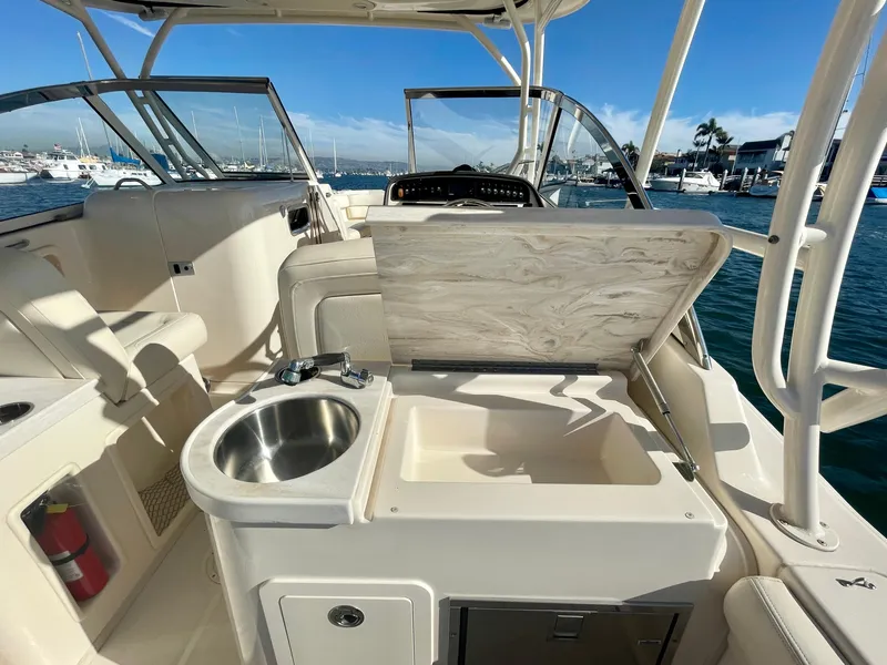 Slide: The Image of 2017 Grady-White 307 Freedom boat interior with sink and seating, docked in a marina. - 20