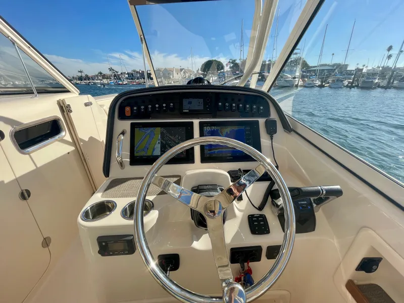 Slide: The Image of 2017 Grady-White 307 Freedom boat helm with navigation screens and steering wheel. - 32