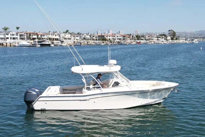 Slide: The Image of 2017 Grady-White Freedom 307 boat cruising in a scenic harbor setting. - 4