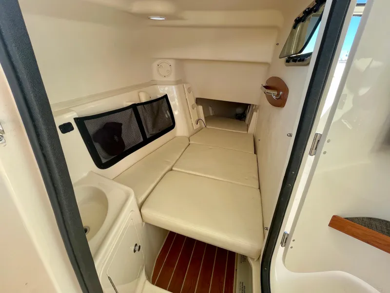 Slide: The Image of 2017 Grady-White 307 Freedom cabin interior with cushioned seating and wooden flooring. - 48