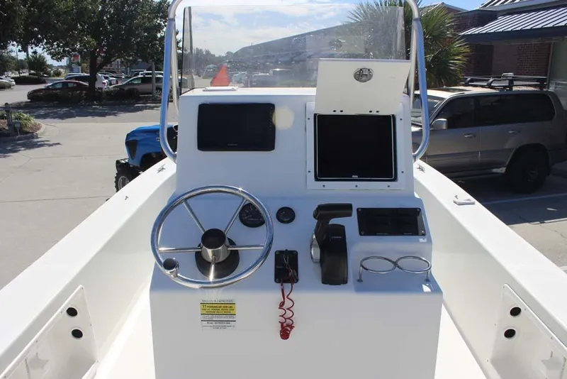 Slide: The Image of 2019 Bay Rider 2060 Skiff console with steering wheel and controls in a parking lot. - 10