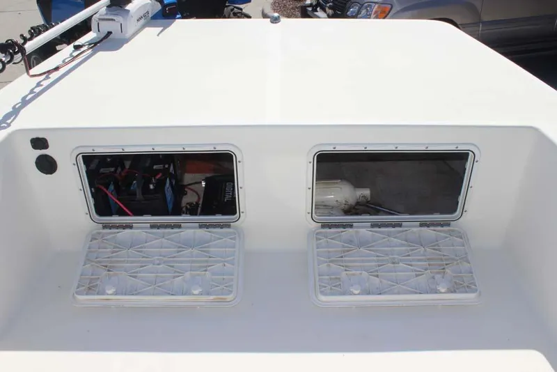 Slide: The Image of 2019 Bay Rider 2060 Skiff boat compartments with open hatches and visible equipment. - 16