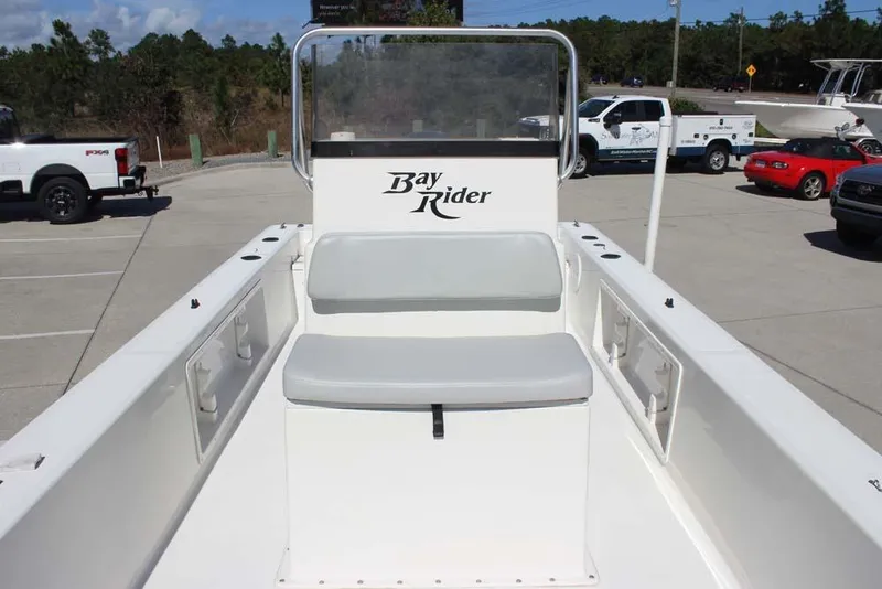 Slide: The Image of 2019 Bay Rider 2060 Skiff boat interior with seating, parked in a lot. - 17