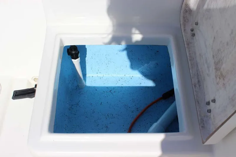 Slide: The Image of Open storage compartment on 2019 Bay Rider 2060 Skiff boat, featuring blue interior. - 23