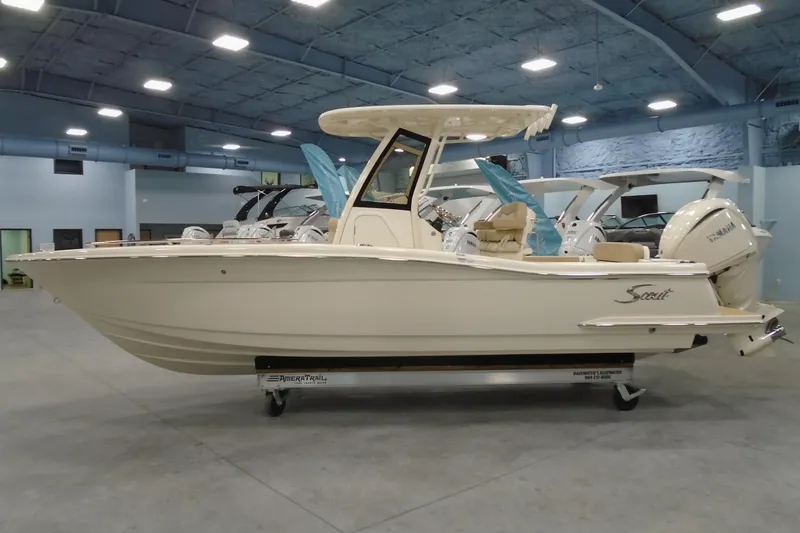 Slide: The Image of 2026 Scout 240 XSF boat in showroom, side view, beige color, on trailer. - 24