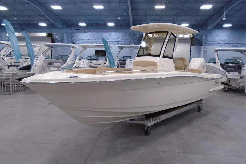 Slide: The Image of 2026 Scout 240 XSF boat displayed in a showroom with other boats. - 25