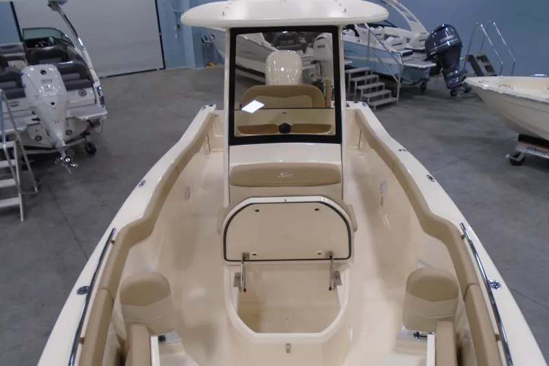 Slide: The Image of 2026 Scout 240 XSF boat interior, showcasing seating and helm in a showroom. - 41