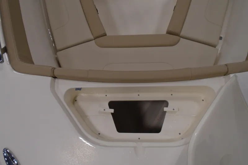 Slide: The Image of 2026 Scout 240 XSF boat interior with tan seating and storage compartment. - 43