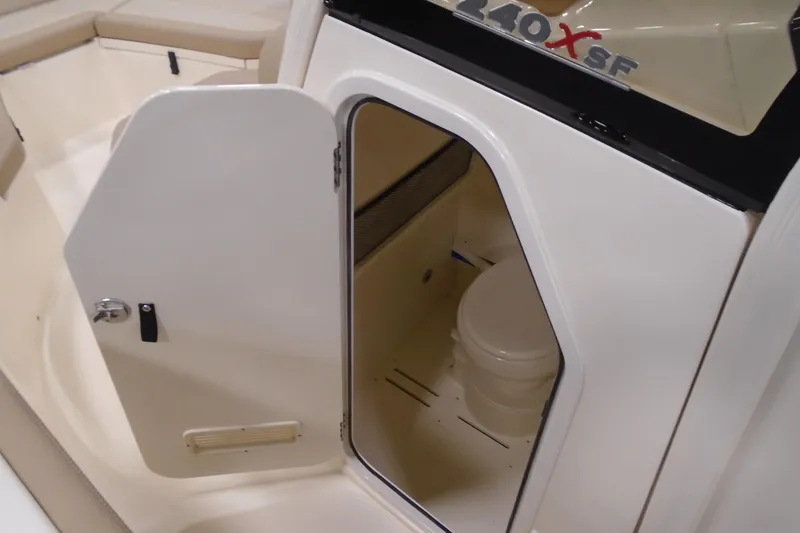 Slide: The Image of 2026 Scout 240 XSF boat interior with open door revealing compact toilet. - 46