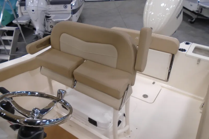 Slide: The Image of 2026 Scout 240 XSF boat interior with beige seating and chrome steering wheel. - 49