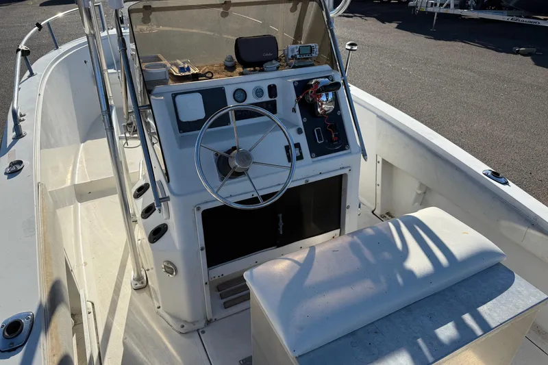 Slide: The Image of 1990 Larson DC-204 boat cockpit with steering wheel and control panel. - 10