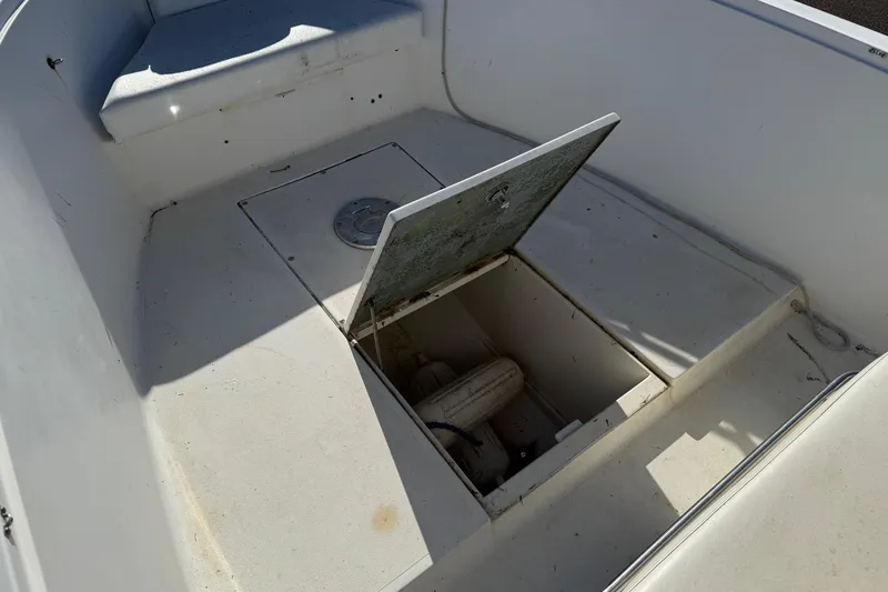 Slide: The Image of Open storage compartment on 1990 Larson DC-204 boat deck, revealing interior components. - 18
