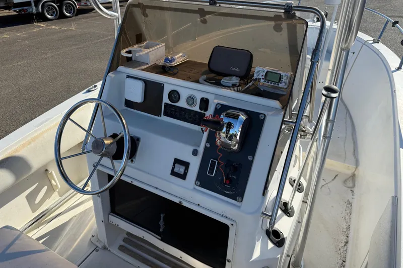 Slide: The Image of 1990 Larson DC-204 boat dashboard with steering wheel and control panel. - 11