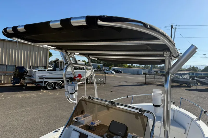 Slide: The Image of 1990 Larson DC-204 boat with canopy, parked in a lot with other boats. - 15