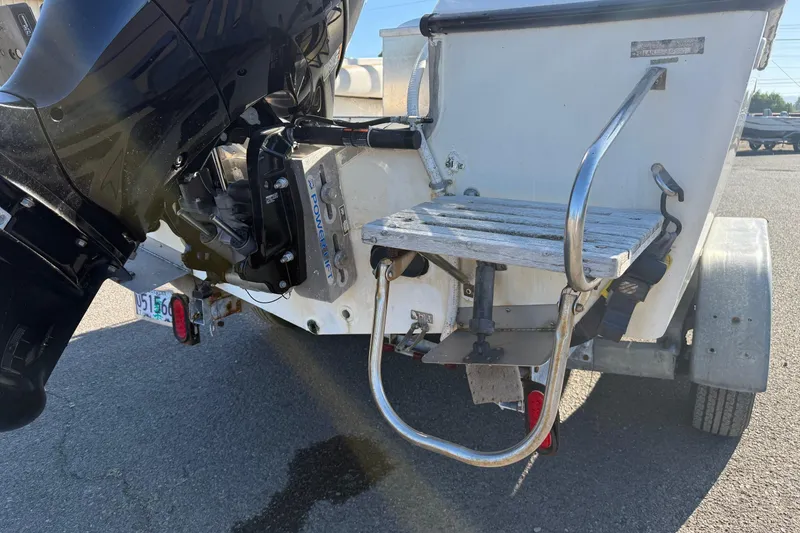 Slide: The Image of Rear view of a 1990 Larson DC-204 boat with outboard motor and swim platform. - 7