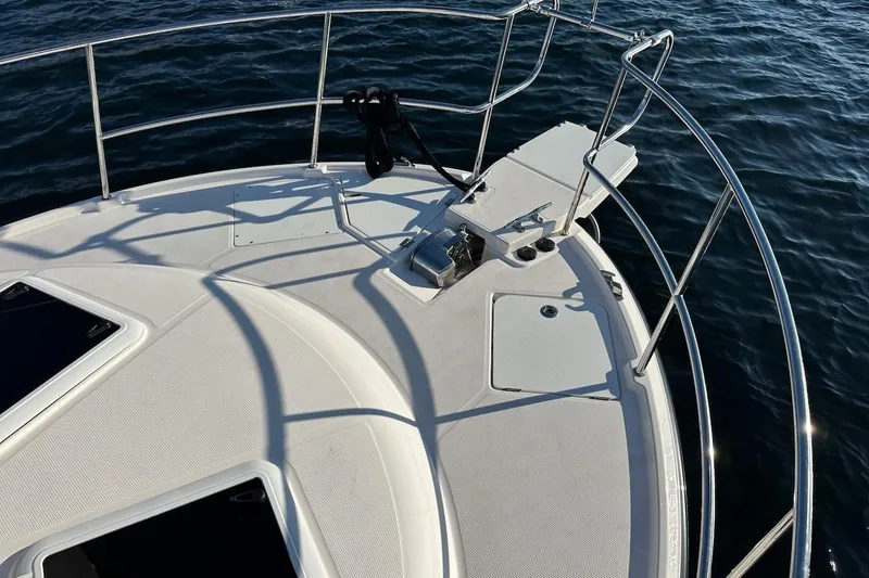 Slide: The Image of Bow of 2025 Ranger Tugs R-29 CB boat with railing and anchor, on water. - 11