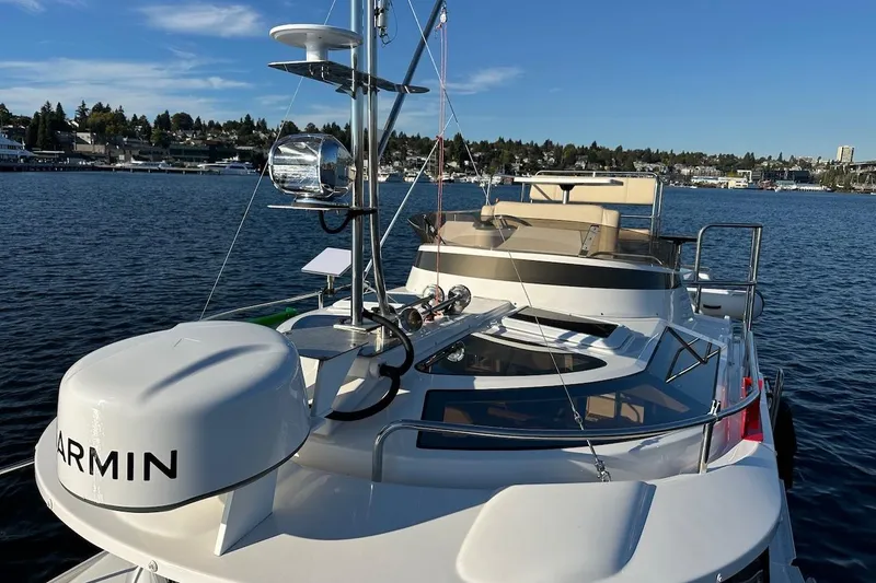 Slide: The Image of 2025 Ranger Tugs R-29 CB boat on water, featuring Garmin equipment and scenic waterfront view. - 14