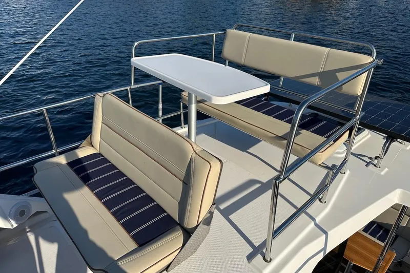 Slide: The Image of 2025 Ranger Tugs R-29 CB boat deck with seating and table, overlooking water. - 17