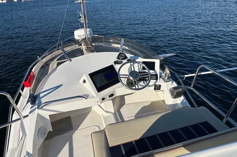 Slide: The Image of 2025 Ranger Tugs R-29 CB helm with navigation screens on open water. - 19