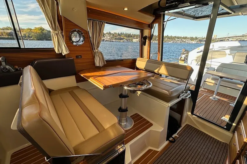 Slide: The Image of 2025 Ranger Tugs R-29 CB interior with elegant seating and scenic water view. - 25
