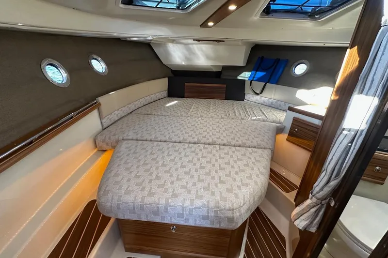 Slide: The Image of 2025 Ranger Tugs R-29 CB interior cabin with cozy bed and elegant wood finishes. - 36