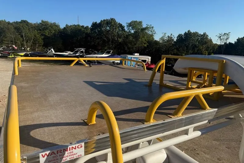 Slide: The Image of 2022 Aloha Pontoon Tropical 260/W with yellow railings, parked outdoors. - 12