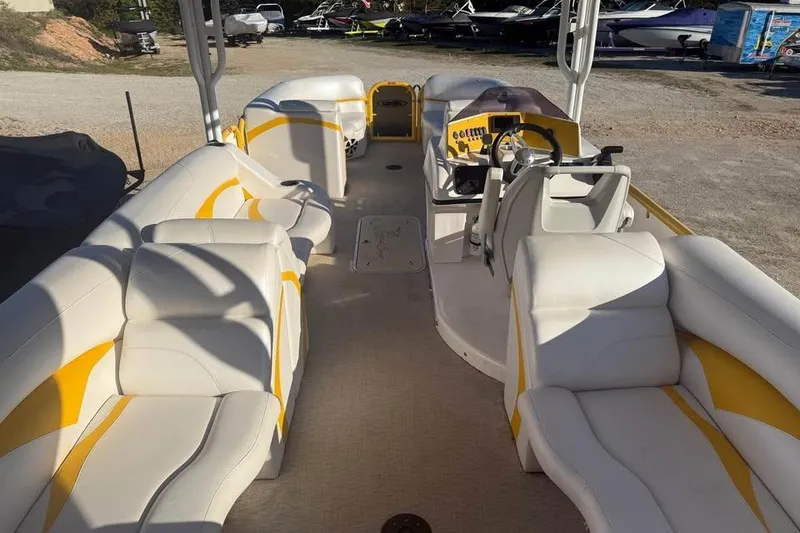 Slide: The Image of 2022 Aloha Pontoon Tropical 260/W with white and yellow seating, spacious deck, and steering console. - 6