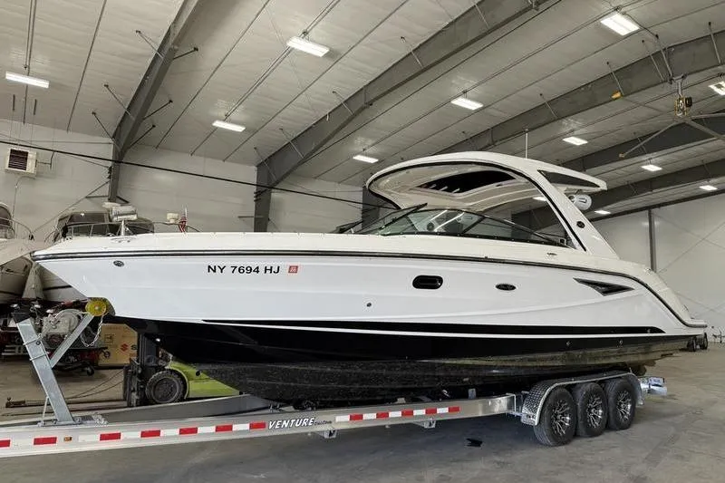 The Image of 2023 Sea Ray SLX 310 boat on trailer in indoor storage facility. - 0