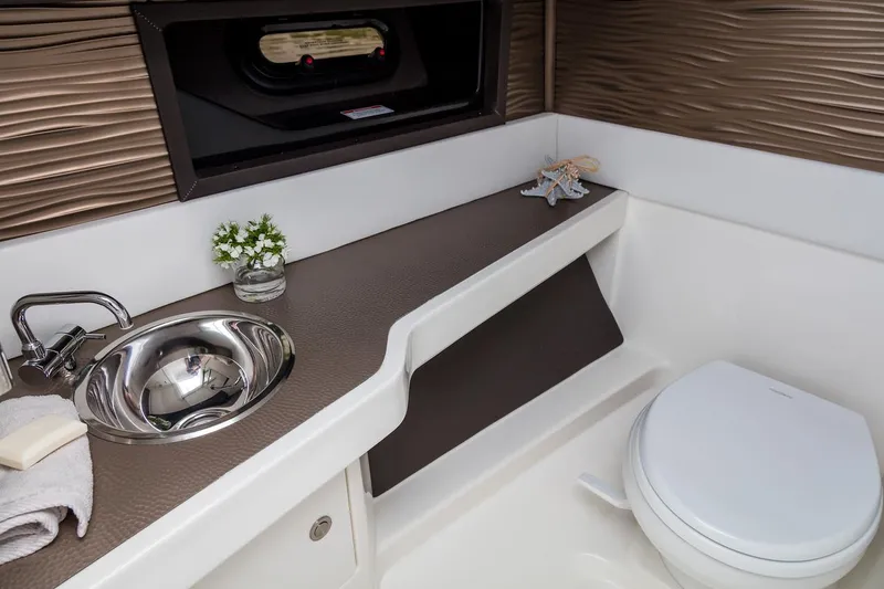 Slide: The Image of 2023 Sea Ray SLX 310 boat interior with cushioned seating and triangular table. - 16