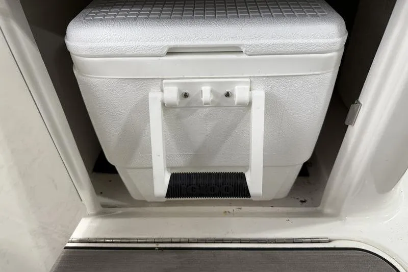 Slide: The Image of White cooler stored in a compartment of a 2023 Sea Ray SLX 310 boat. - 18