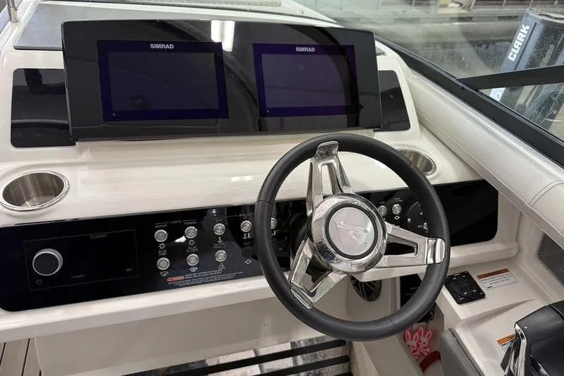 Slide: The Image of 2023 Sea Ray SLX 310 helm with dual Simrad displays and modern steering wheel. - 20