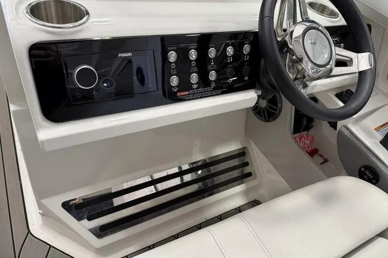 Slide: The Image of 2023 Sea Ray SLX 310 helm with steering wheel and control panel. - 21