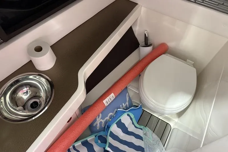 Slide: The Image of 2023 Sea Ray SLX 310 boat interior with toilet, sink, and accessories. - 27