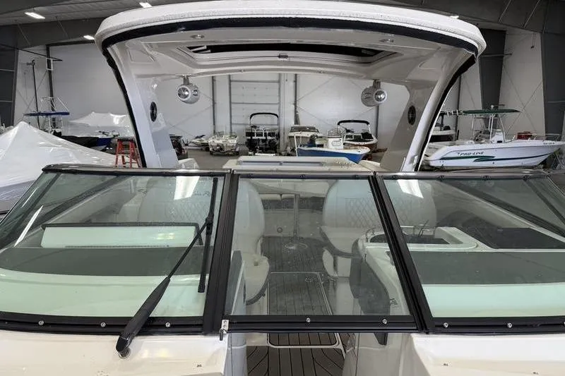 Slide: The Image of 2023 Sea Ray SLX 310 boat interior in a showroom, featuring sleek design and spacious seating. - 29