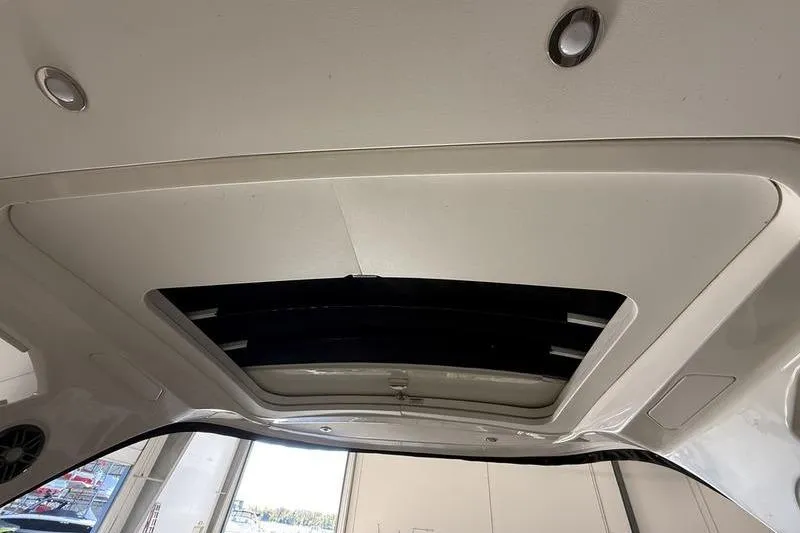 Slide: The Image of 2023 Sea Ray SLX 310 boat interior ceiling with sunroof and lighting fixtures. - 30