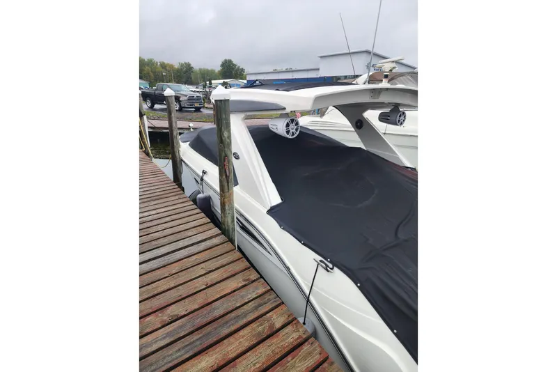 Slide: The Image of 2023 Sea Ray SLX 310 boat docked with black cover and speakers. - 39