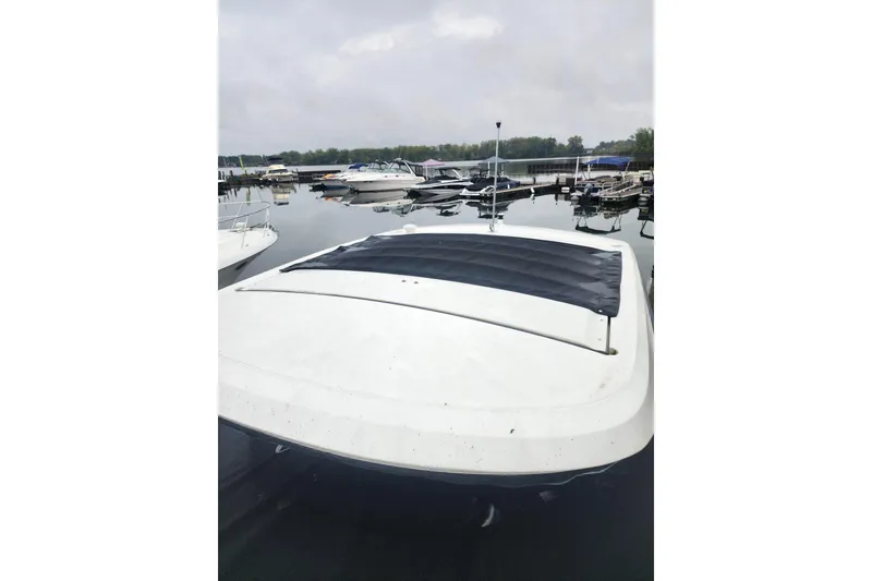Slide: The Image of 2023 Sea Ray SLX 310 boat docked at a marina on a cloudy day. - 40