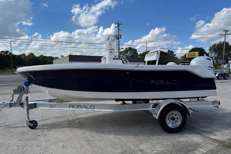 The Image of 2026 Robalo R160 Center Console boat on trailer under blue sky. - 1