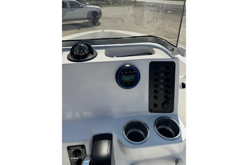 Slide: The Image of 2026 Robalo R160 Center Console dashboard with compass, controls, and cup holders. - 12