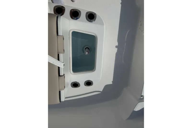 Slide: The Image of 2026 Robalo R160 Center Console boat interior with storage compartment and cup holders. - 6