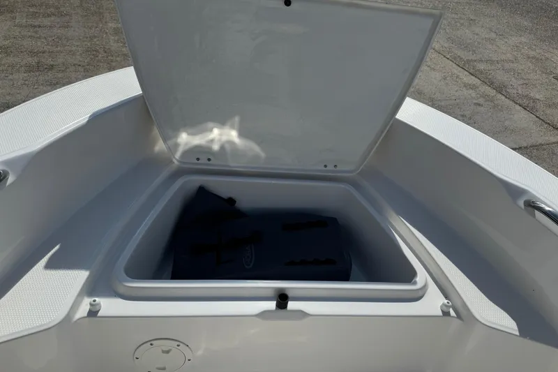 Slide: The Image of 2026 Robalo R160 Center Console boat storage compartment open, showing interior space. - 7