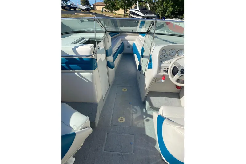 Slide: The Image of 1996 Crownline 266 BR boat interior with blue and white seating and dashboard. - 2