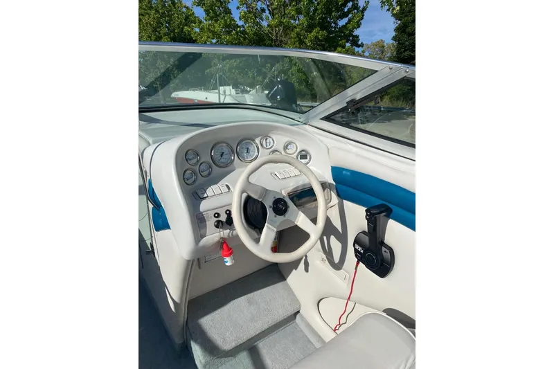 Slide: The Image of 1996 Crownline 266 BR boat dashboard with steering wheel and control panel. - 4