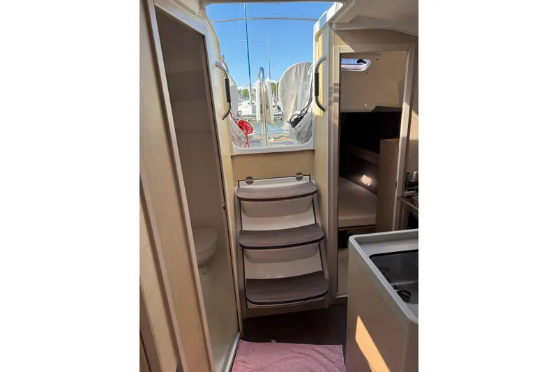 Slide: The Image of Interior view of 2020 Beneteau Oceanis 30.1 sailboat, featuring compact cabin and steps. - 19