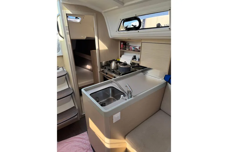 Slide: The Image of Interior of 2020 Beneteau Oceanis 30.1 yacht, featuring compact kitchen and cozy cabin space. - 22