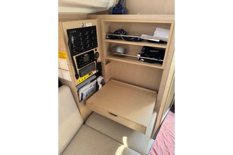 Slide: The Image of Beneteau Oceanis 30.1 interior navigation station with control panel and storage shelves. - 26