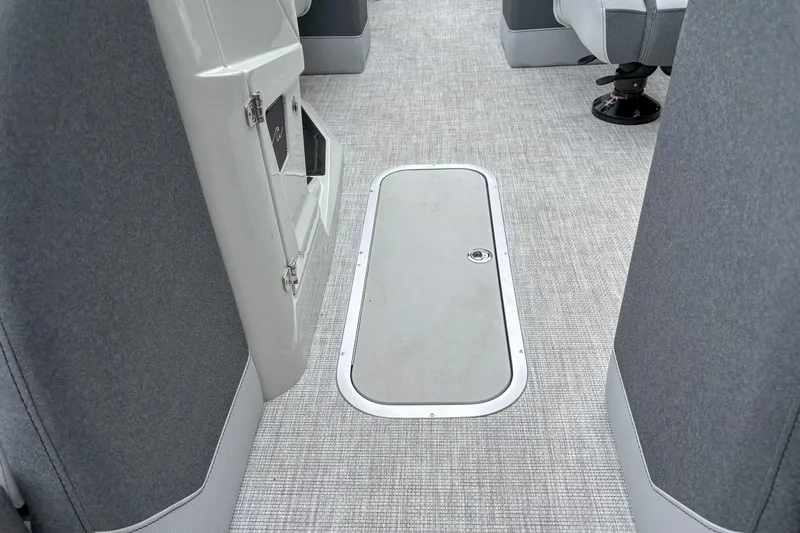 Slide: The Image of Interior of 2026 Alera M23Q boat with gray carpet and storage hatch. - 6